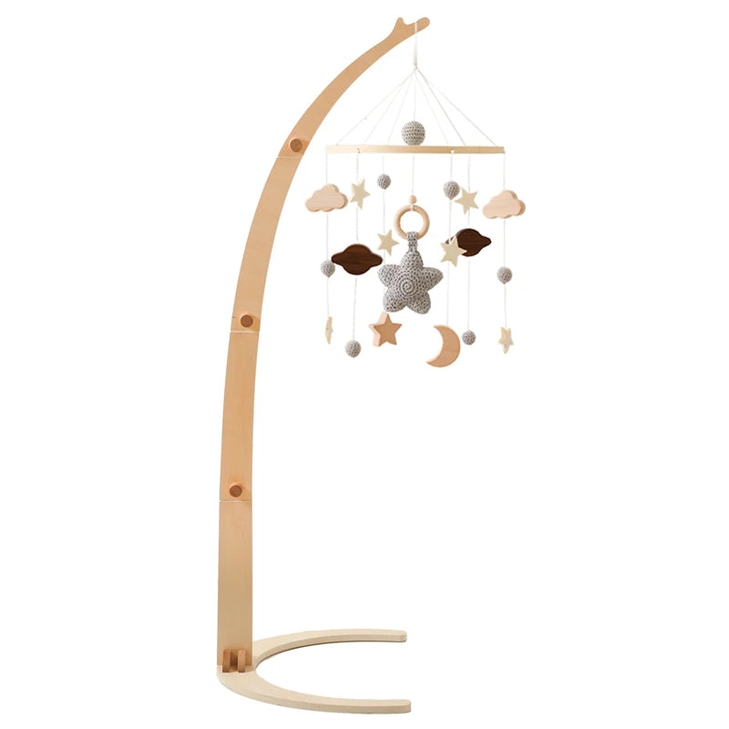 Wooden baby mobile with a curved stand, featuring hanging stars, planets, clouds, and a textured star centerpiece in beige and brown tones on a white background.