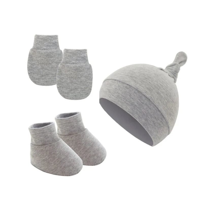 Gray baby clothing set includes a knot-top hat, a pair of booties, and a pair of mittens. All items are made of soft fabric designed for warmth and comfort.