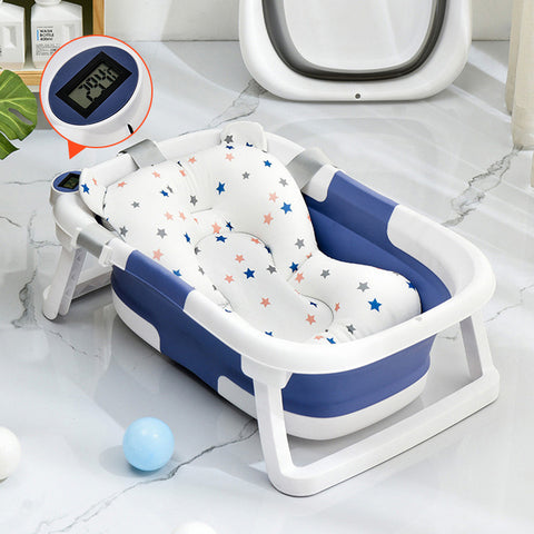A blue and white baby bathtub with star-patterned padding sits on a marble floor. It features a digital thermometer screen displaying "79.8°F" for water temperature.