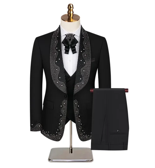 Elegant black mariachi suit on a mannequin, featuring intricate silver embroidery. Includes a white shirt, black bow, matching vest, and pants draped on a stand.
