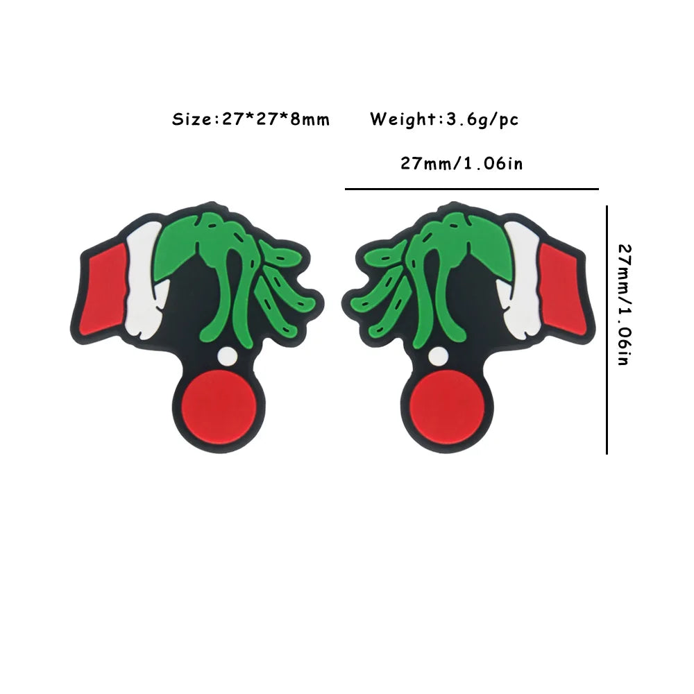 Two green hands with Santa hats grasp red baubles. Dimensions: 27x27x8mm, weight 3.6g per piece. The design is cartoonish and festive, suitable as charms or decorations.