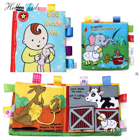 Colorful fabric children's books with animal illustrations. Pages feature a baby with a bunny, elephants, sheep, and a cow in a barn, with textured tags for tactile engagement.