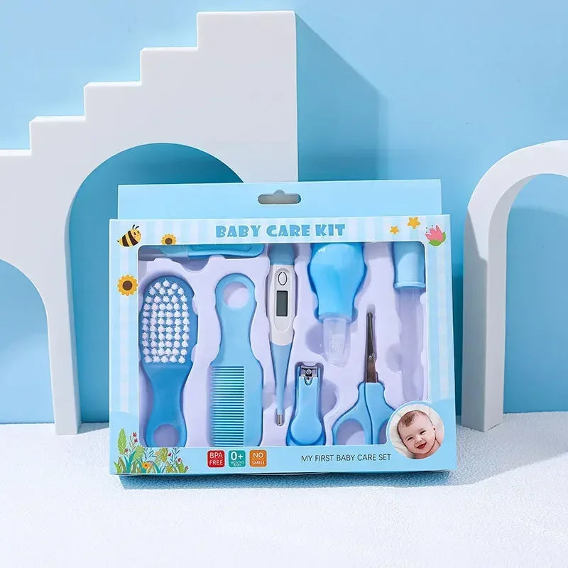 Baby care kit with blue accessories including a brush, comb, digital thermometer, nasal aspirator, nail clippers, and scissors, set against a pastel background with arch shapes.
