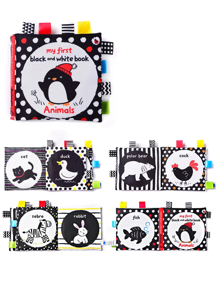 Soft baby book titled "My First Black and White Book: Animals" with playful illustrations of a penguin, cat, duck, polar bear, rooster, zebra, rabbit, and fish in monochrome and colorful fabric tabs.