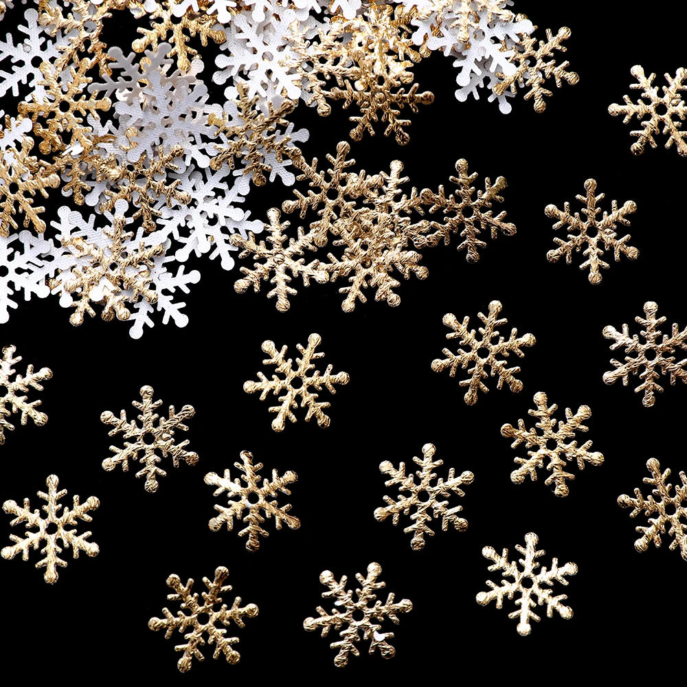 Gold and white snowflake decorations scattered on a black background, creating a festive and elegant pattern.