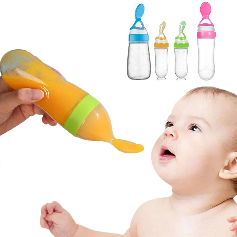 A hand holds a green-tipped baby food dispensing bottle, feeding orange puree to a baby. Three additional bottles with blue, yellow, and pink tips are displayed in the background.