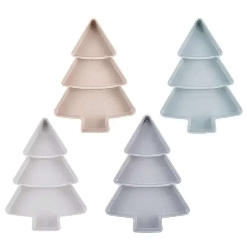 Four Christmas tree-shaped trays in pastel colors: beige, light blue, white, and gray, arranged against a white background. Each tray has three sections for holding items.