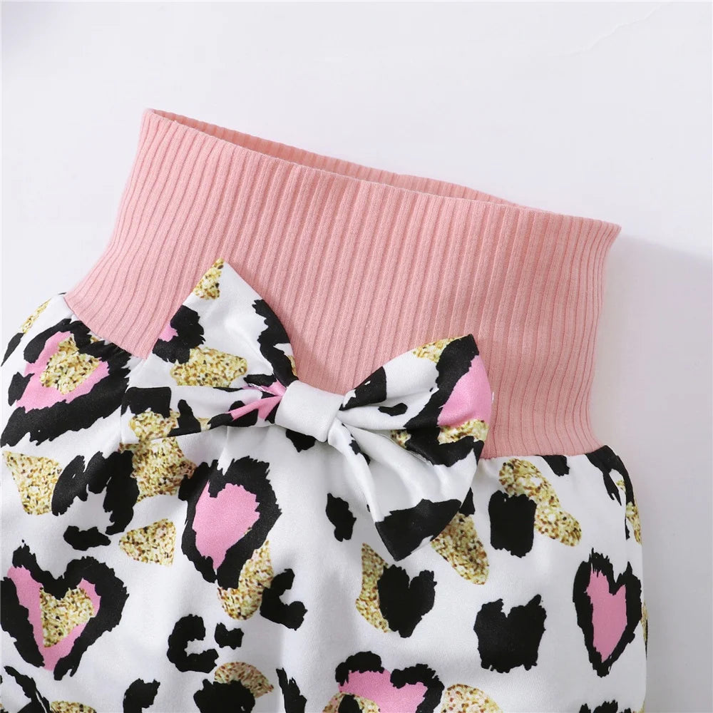 Pink ribbed waistband with a bow on white fabric featuring a leopard print in black, pink, and gold.
