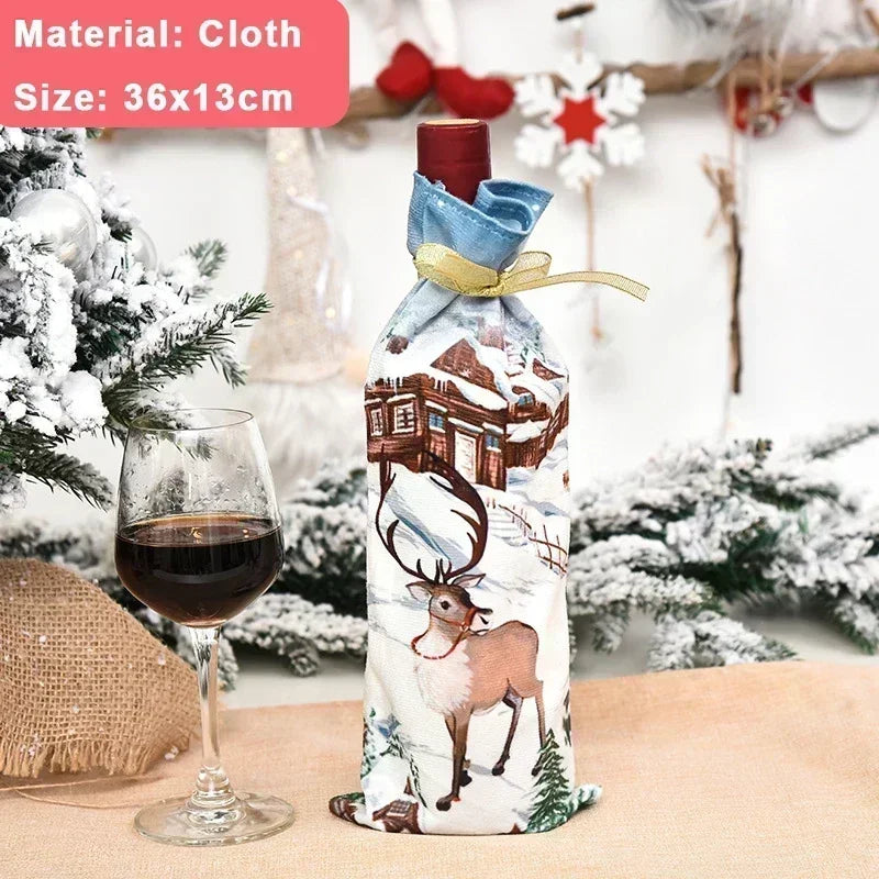 Festive wine bottle in a cloth cover with a reindeer design, beside a glass of red wine. Snowy decor and a burlap cloth add to the wintery theme. Size: 36x13cm.