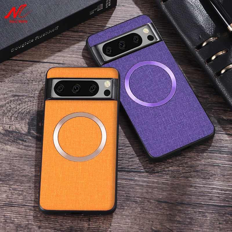 Two smartphones with textured orange and purple cases featuring circular designs, placed on a wooden surface near a black leather planner and a book titled "Douglas Rushkoff."