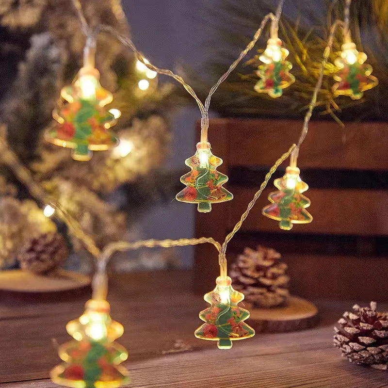 Festive string lights shaped like Christmas trees glow warmly. Set against a cozy background with pinecones, evoking a holiday atmosphere.
