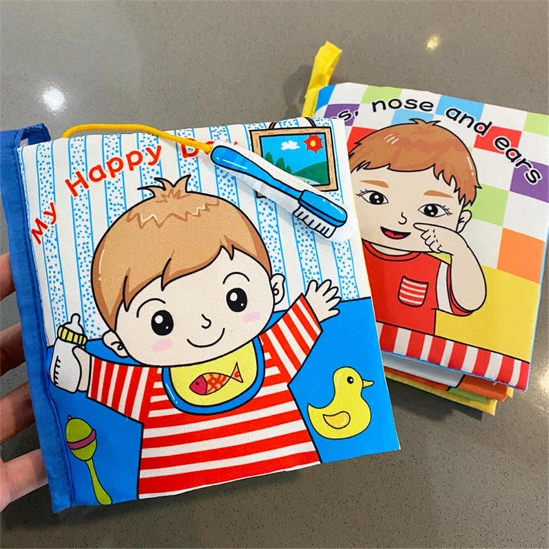 Colorful cloth baby books featuring cartoon children, one holding a bottle and toothbrush with a rubber duck image, and another showing a child touching their face.