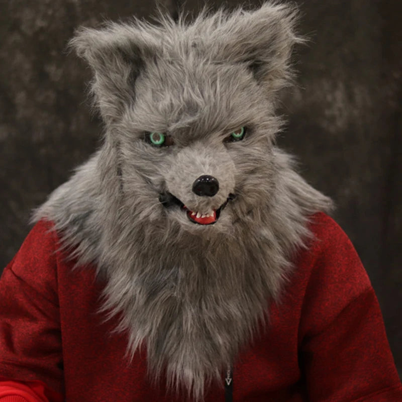 A person wearing a realistic werewolf mask with sharp teeth and green eyes, dressed in a red shirt, against a dark background.