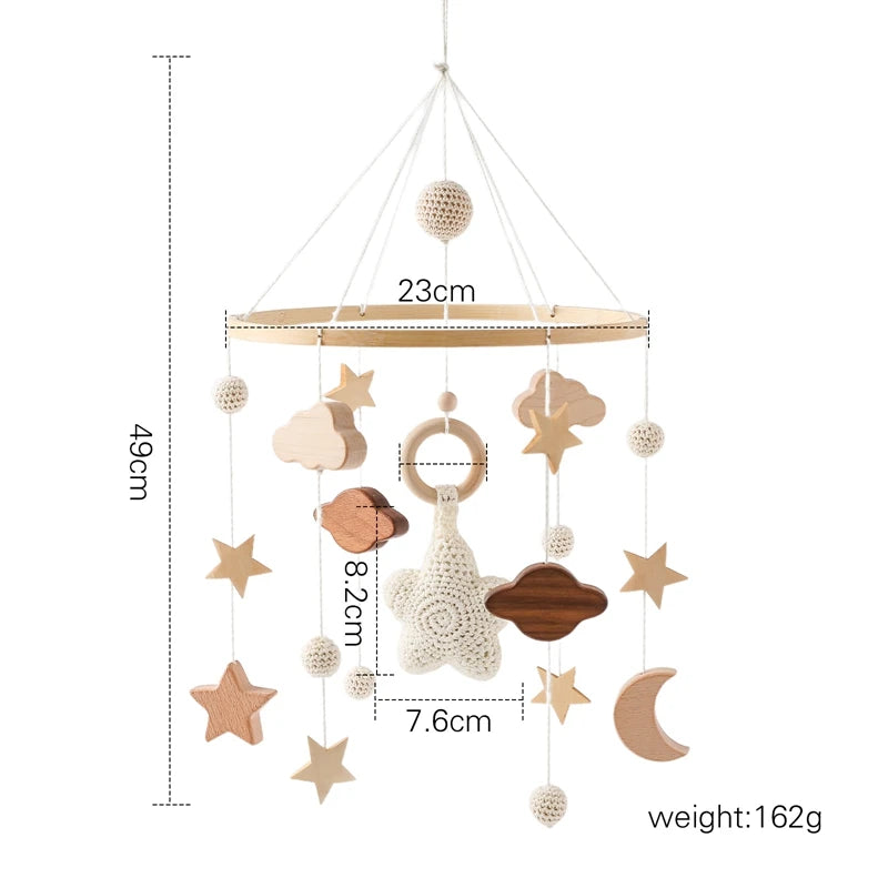 Wooden baby mobile with stars, clouds, and a moon, hanging from a 23cm frame. Length is 49cm, with elements measuring 8.2cm and 7.6cm. Total weight is 162g.