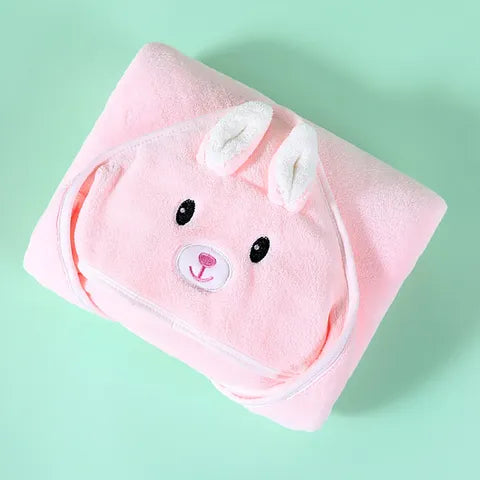 Pink hooded baby towel with embroidered cute rabbit face and ears, folded neatly on a light green background. Soft fabric suggests cozy, playful design.
