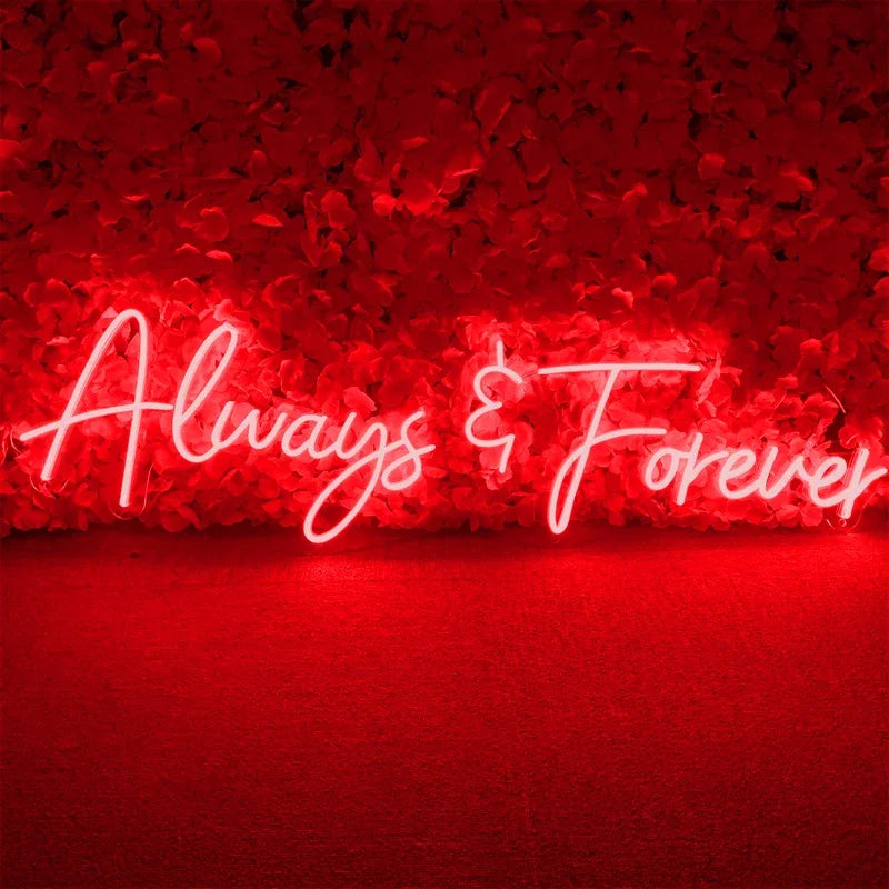 Neon sign reading "Always & Forever" in elegant script, glowing against a vibrant red floral background, creating a romantic and warm atmosphere.
