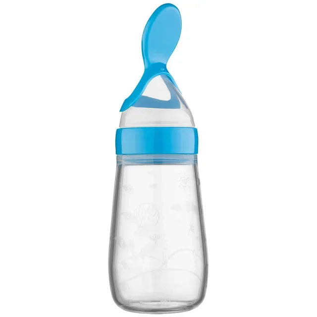 Clear baby feeding bottle with a blue screw-on spoon. The bottle features embossed patterns of animals and plants, designed for convenience in feeding purees or liquids.