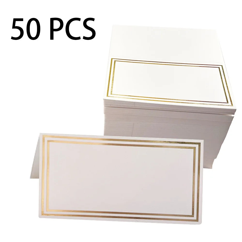 Stack of 50 white place cards with gold borders, one card displayed in front tent-folded.