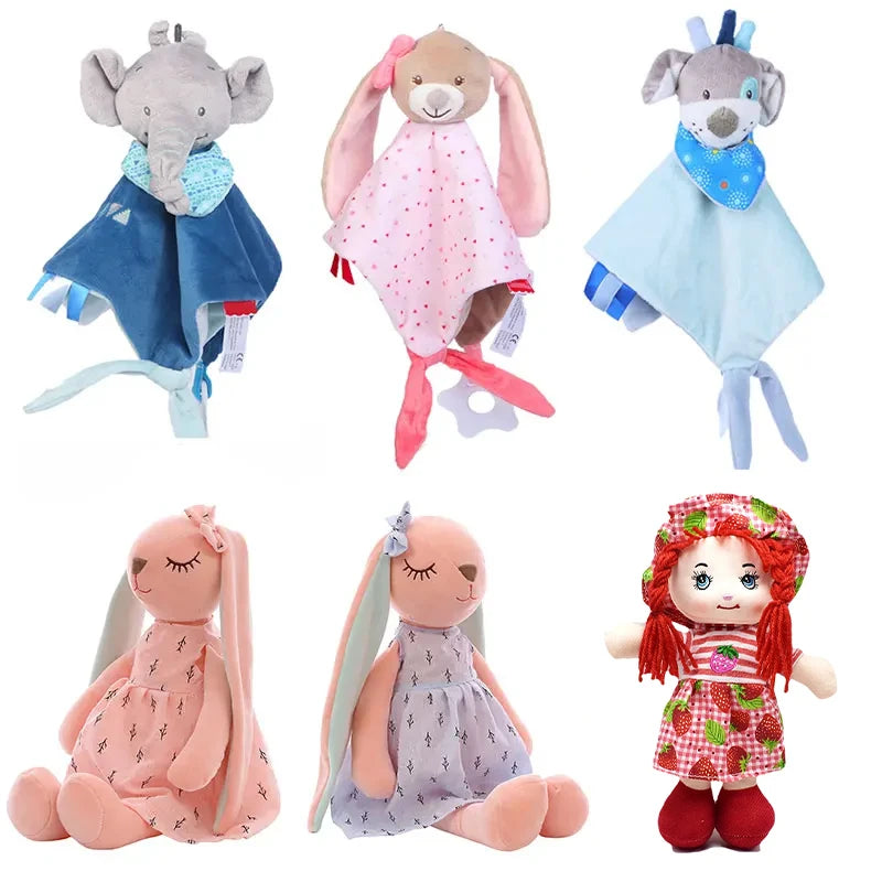 Soft toy assortment including animal-themed comforters and plush dolls. Features an elephant, bunny, dog comforters, two seated bunnies in dresses, and a doll with red hair.