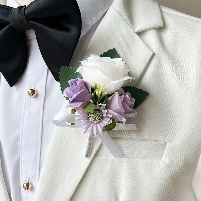 A close-up of a white suit jacket with a black bow tie and a boutonniere featuring a white rose, purple flowers, and green leaves pinned to the lapel.