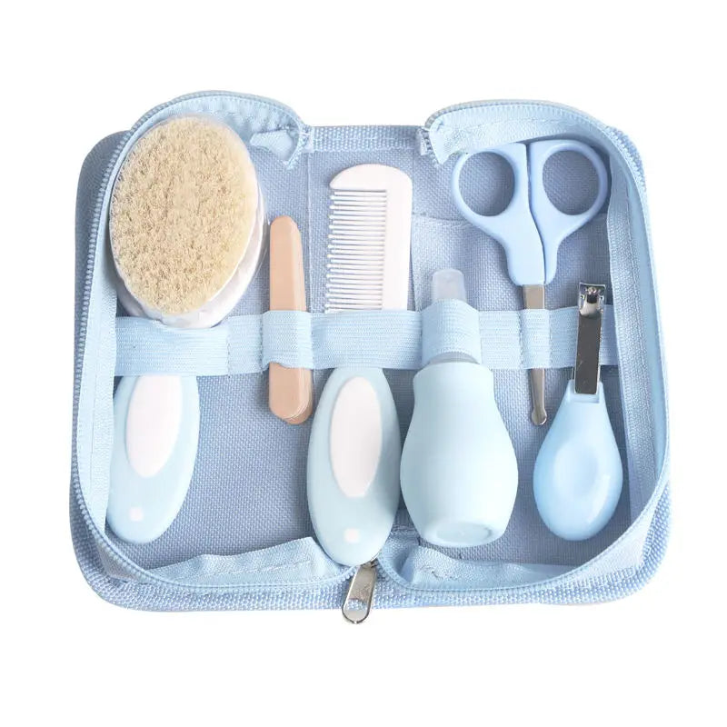 A blue baby grooming kit with a brush, comb, nail file, scissors, medicine dropper, nasal aspirator, and nail clippers neatly arranged in a zippered case.