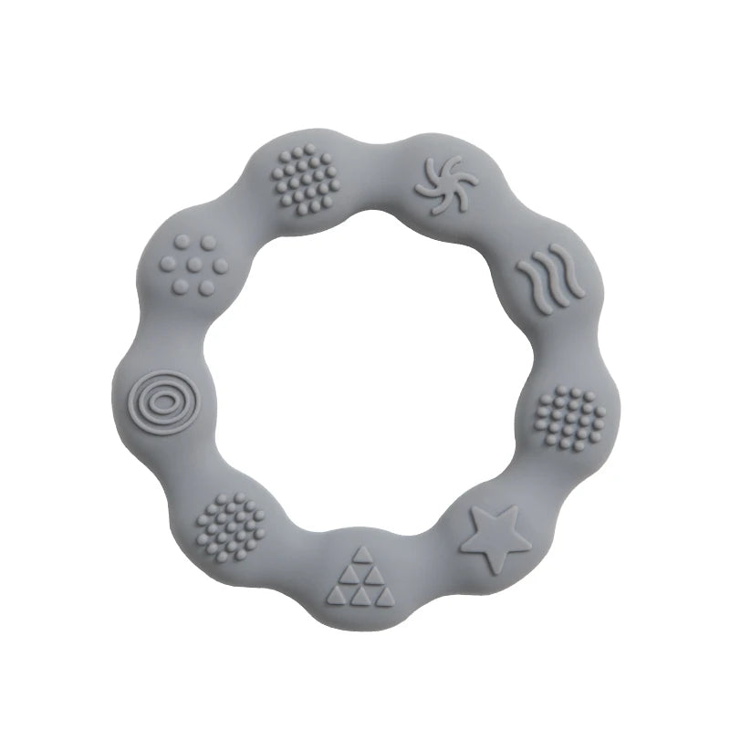 Gray silicone teething ring with wavy edges featuring various textured patterns, including circles, a star, triangles, and wavy lines, for sensory stimulation.