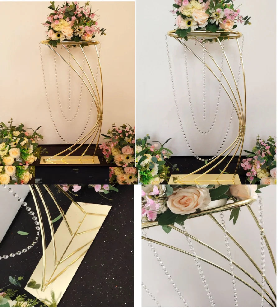 Gold metal flower stand with crystal bead chains, holding a lush floral arrangement of roses and pink blossoms. Surrounded by more flowers, emphasizing elegance and sophistication.