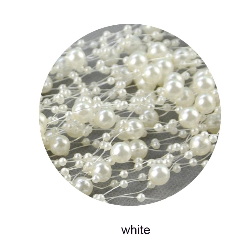 Close-up of a cluster of white faux pearl beads on clear strings, arranged in a decorative pattern. The beads vary in size and are shown in a circular frame.