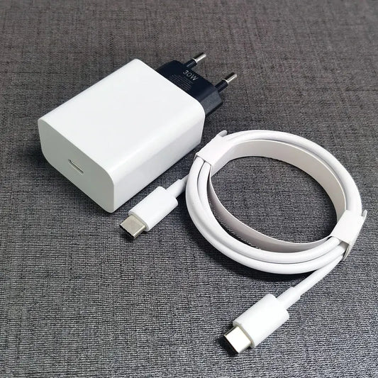 A 30W USB-C power adapter with a white, coiled USB-C to USB-C charging cable on a gray fabric surface.
