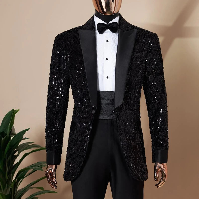 Headless mannequin in a black sequined tuxedo with a shiny black lapel, white dress shirt, and black bow tie. A small plant is in the background.