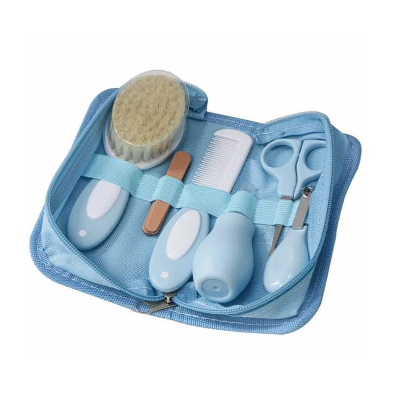 Blue baby grooming kit in an open zippered pouch. Includes a soft-bristle brush, comb, nail file, nasal aspirator, safety scissors, and nail clippers, all secured with elastic straps.