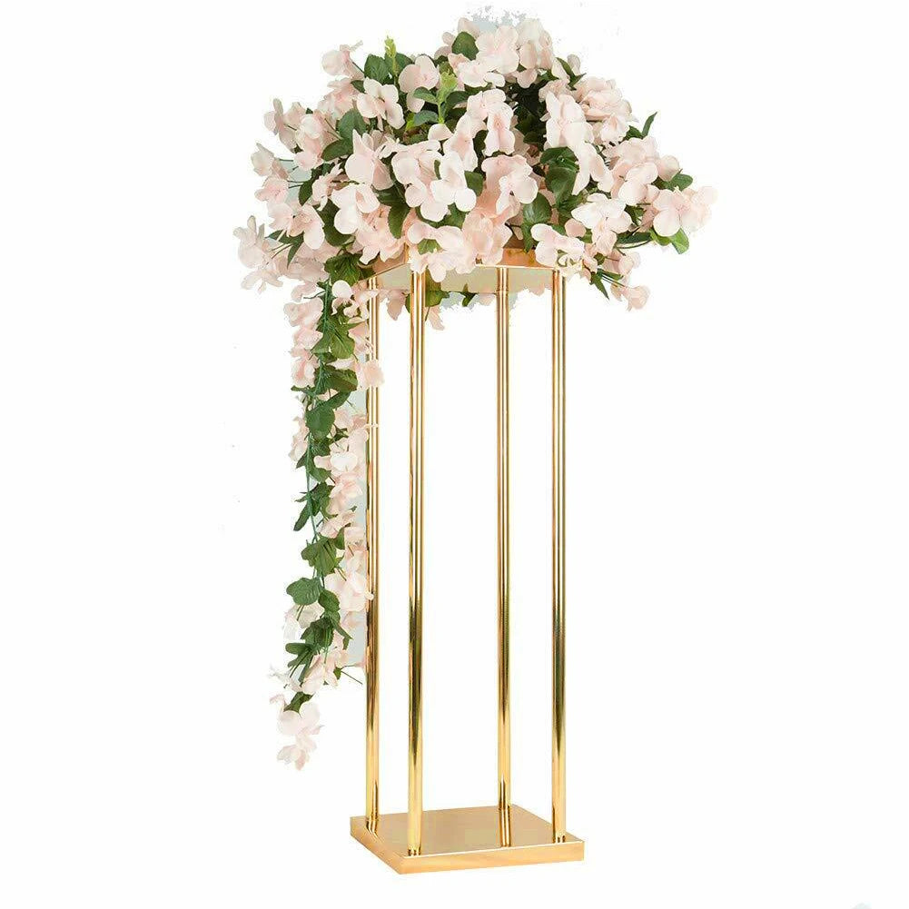 Elegant gold stand adorned with pink flowers and green leaves, cascading down the sides. The arrangement is set against a plain white background.