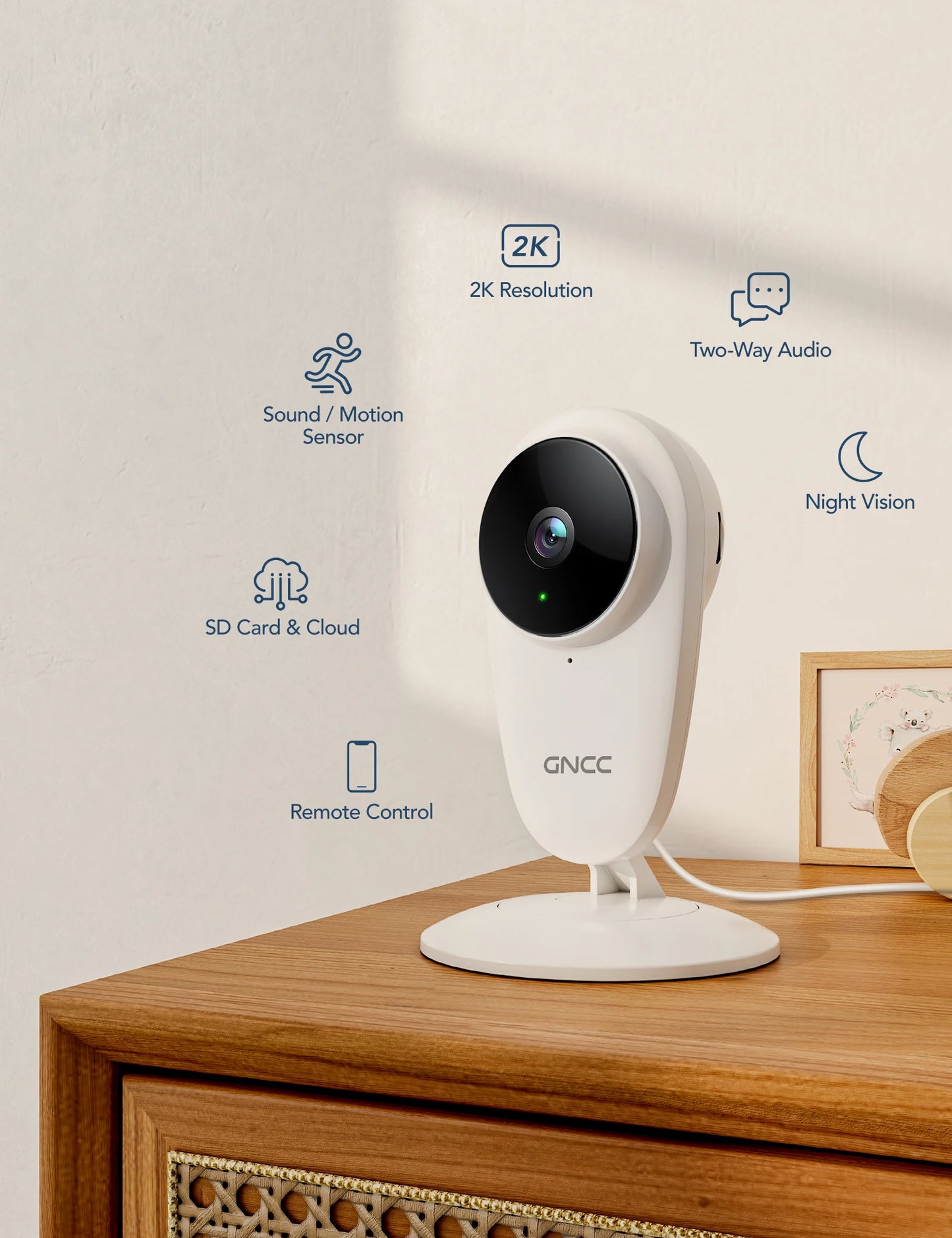 A white GNCC security camera on a wooden table, featuring 2K resolution, two-way audio, night vision, sound/motion sensor, SD card/cloud storage, and remote control capabilities.
