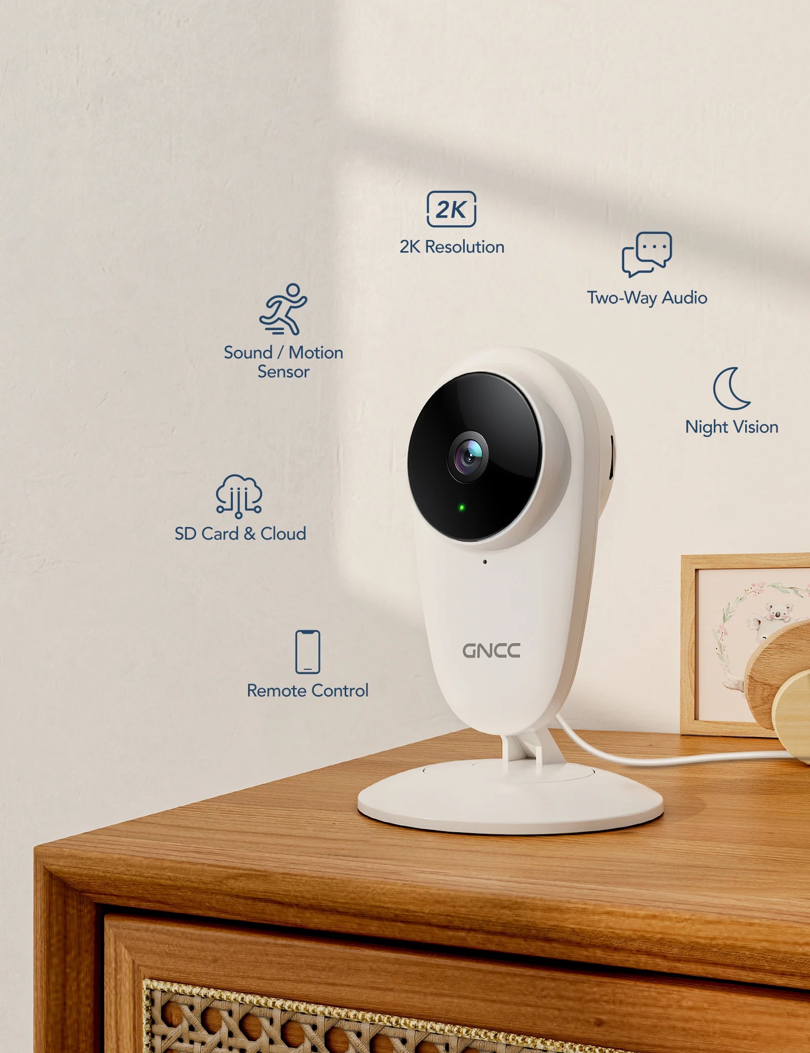 A white GNCC security camera on a wooden table, featuring 2K resolution, two-way audio, night vision, sound/motion sensor, SD card/cloud storage, and remote control capabilities.