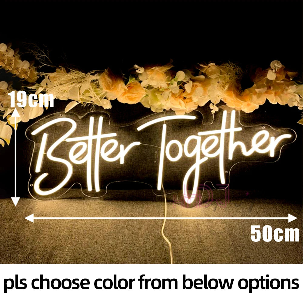 Neon sign reading “Better Together” with floral decoration above, measuring 19cm tall and 50cm wide. Background is dark, highlighting the glowing text.