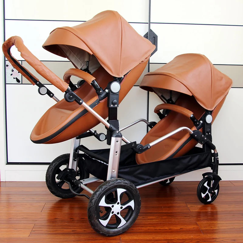 Double stroller with brown leather seats and canopies, silver frame, and four black wheels with silver spokes, placed on a wooden floor indoors.