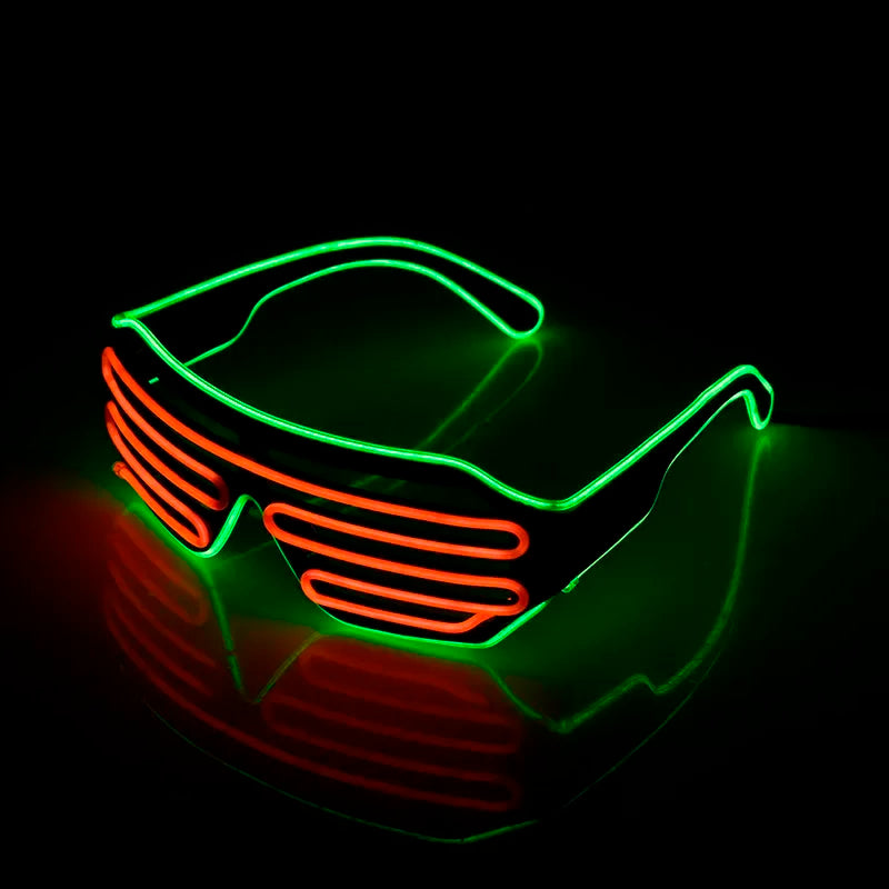 Neon glasses with green frames and red striped lenses glow in the dark, casting reflections on a glossy surface.