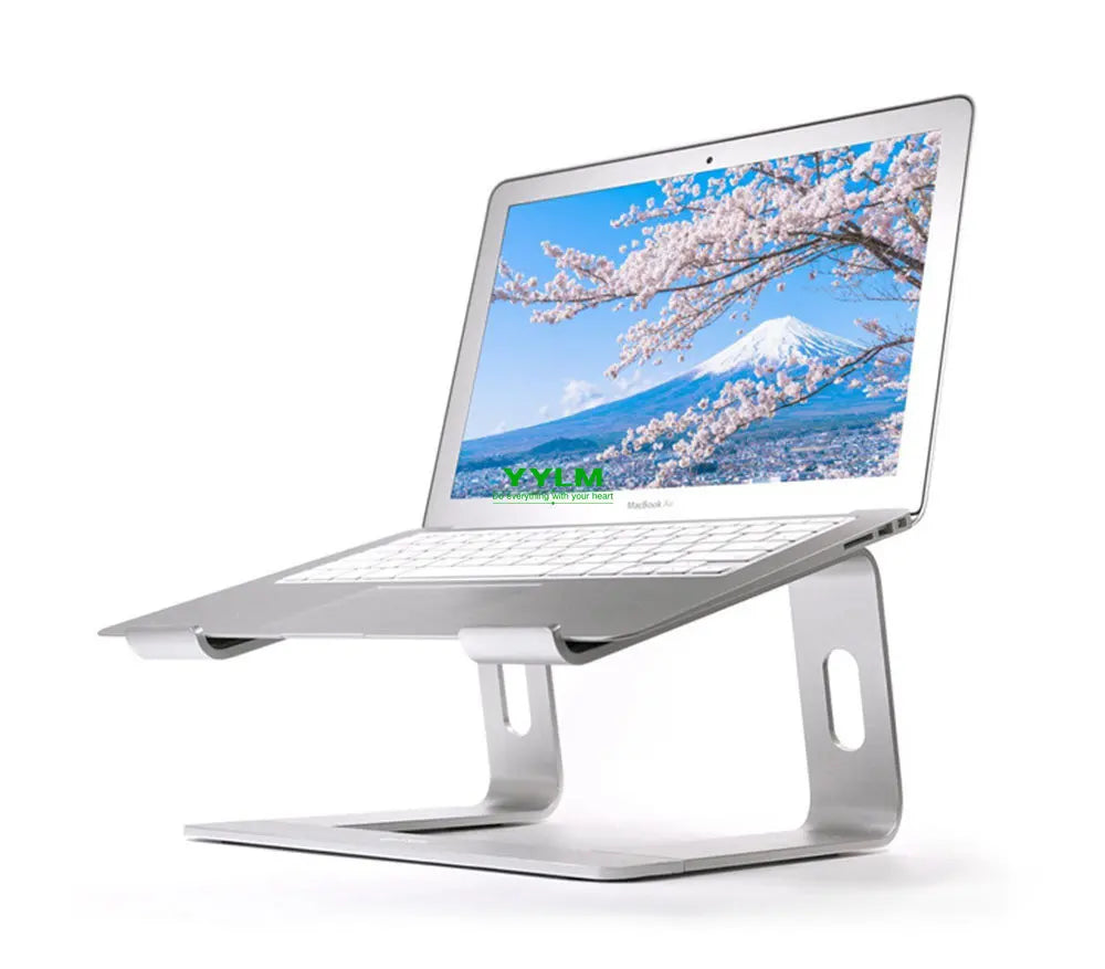 A silver laptop on a sleek metal stand displaying a scenic wallpaper of cherry blossoms and a snow-capped mountain under a clear blue sky.