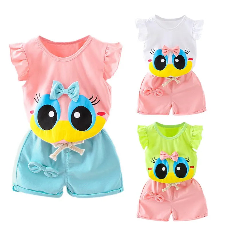 Three colorful toddler outfits featuring a cute cartoon face. The sets come in pink and blue, white and pink, and green and pink with matching shorts and frilly sleeves.