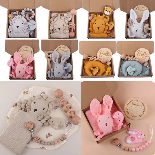 A collection of baby gift boxes featuring soft toys shaped like bears, bunnies, and lions. Each box includes teethers and wooden accessories in pastel colors.