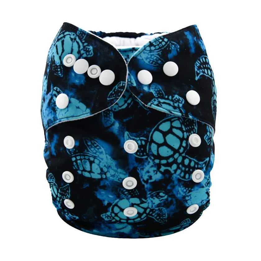A reusable cloth diaper with a black and blue sea turtle pattern, featuring multiple white snap buttons for adjustable sizing.