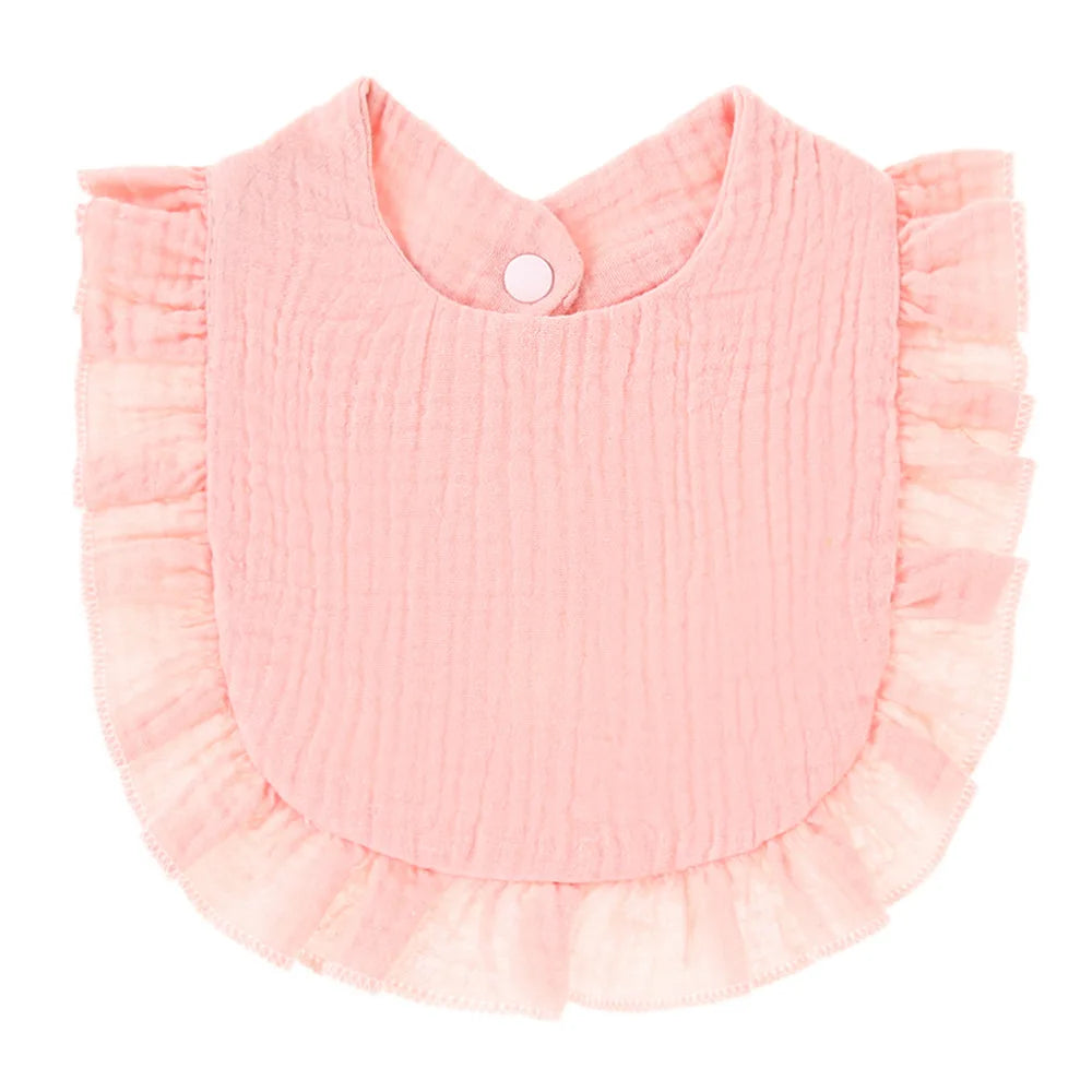 Pink baby bib with textured fabric and ruffled edges. It features a round neck and a snap button closure at the back, designed for easy use.