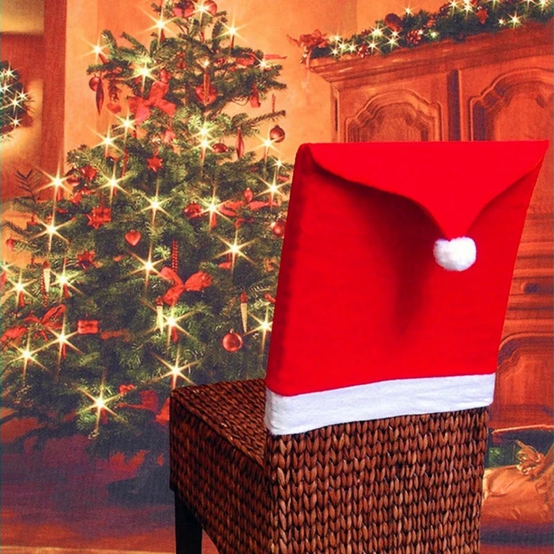A cozy room features a glowing Christmas tree adorned with lights and ornaments. In front, a wicker chair is draped with a red Santa hat chair cover, adding festive charm.