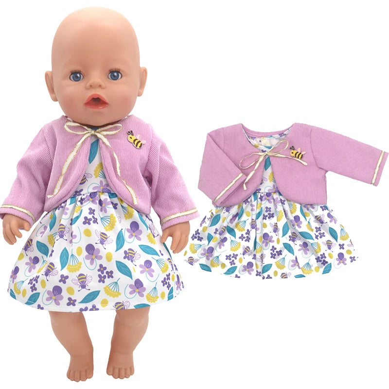 A doll wearing a purple cardigan with a bee applique and a floral dress in shades of purple, yellow, and teal. The same outfit is displayed separately to the right.