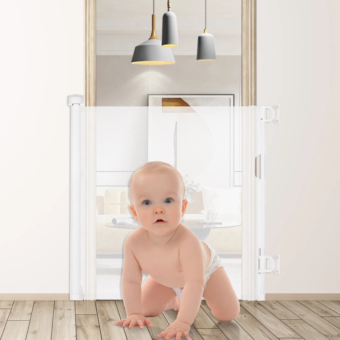 A baby in a diaper crawls on a wooden floor in front of a white retractable safety gate, with modern pendant lights hanging in the background.