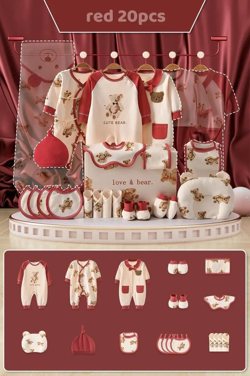 "Red-themed baby clothing set with teddy bear designs includes onesies, hats, bibs, socks, mittens, and towels, displayed on hangers with a backdrop of red curtains."