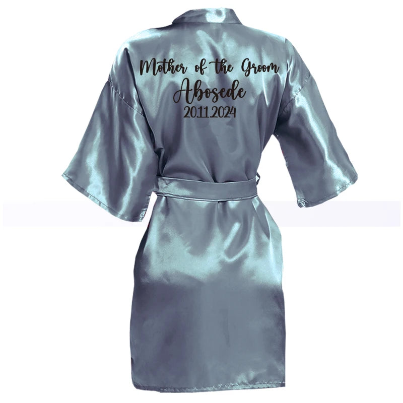 Blue satin robe with "Mother of the Groom," "Abosede," and "2011-2024" printed in black on the back.