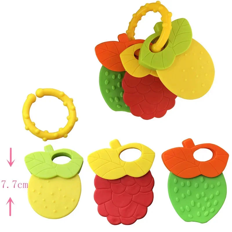 Colorful fruit-shaped baby teethers with leaf handles and bumpy textures, including strawberry, pineapple, and raspberry designs. A yellow ring is also included. Length indicated as 7.7 cm.