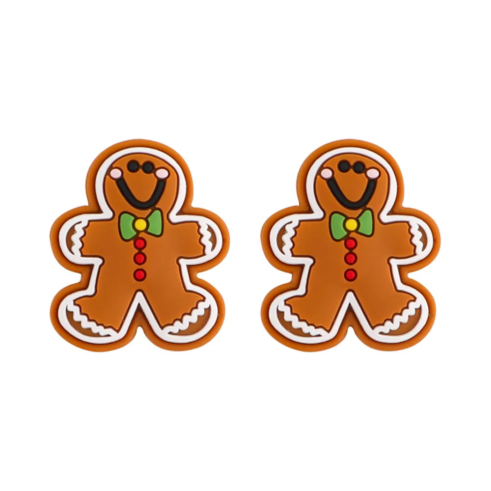 Two smiling gingerbread man figures with green bow ties and red buttons, decorated with white icing details, are side by side on a white background.