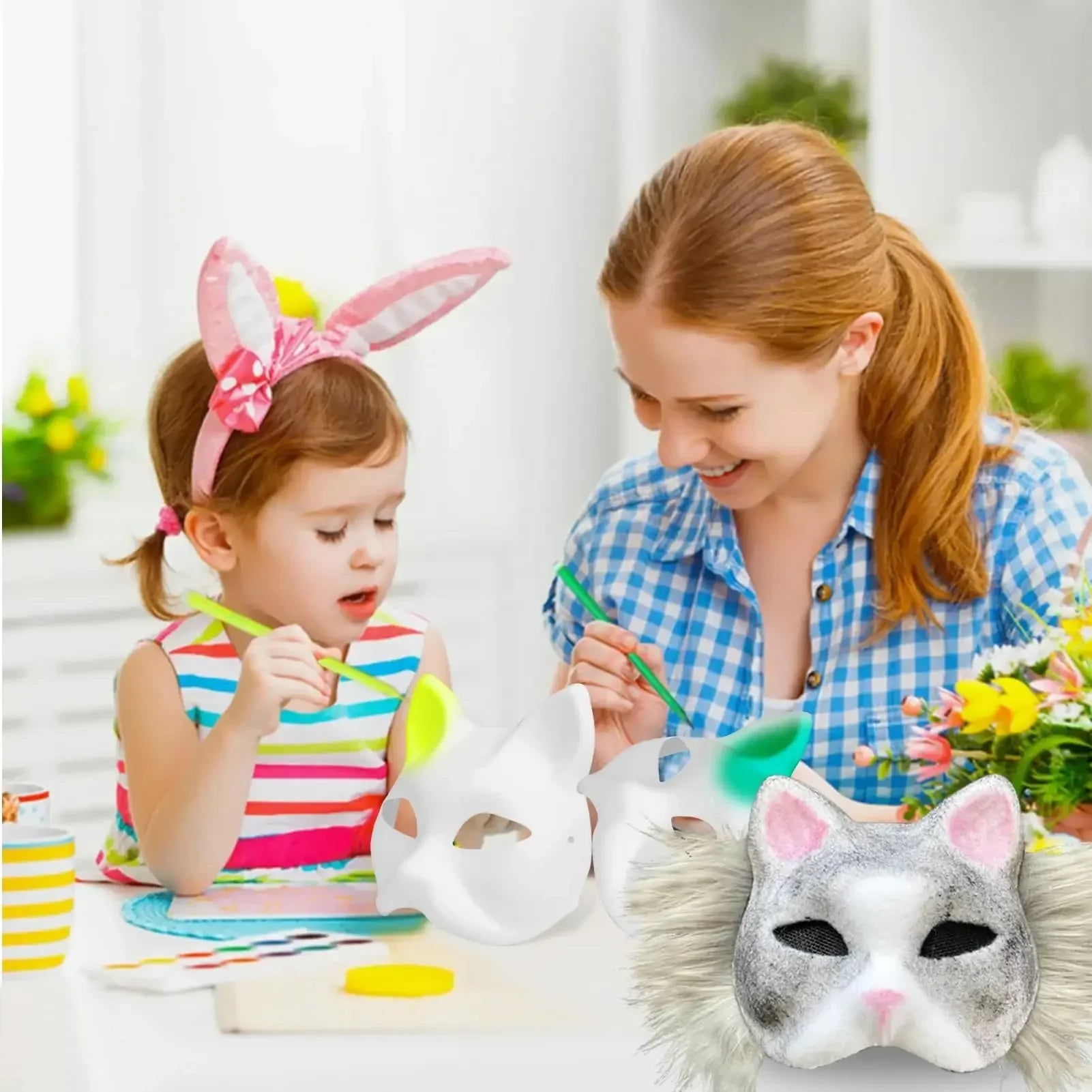 A mother and daughter paint animal masks together at a table. The girl wears bunny ears, and colorful masks lie in front of them. A vase of flowers is in the background.